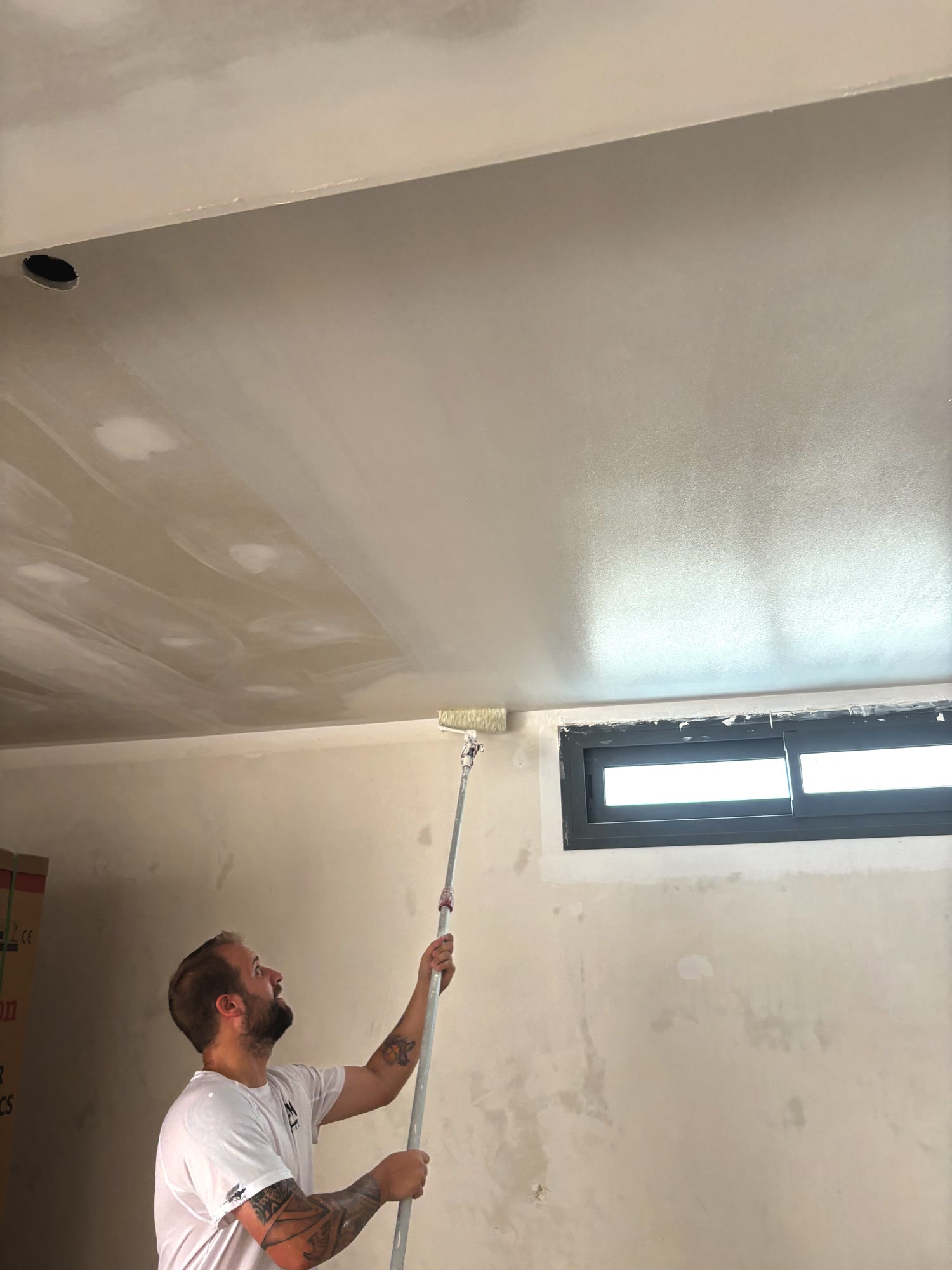 Repasando el techo junto a la ventana
